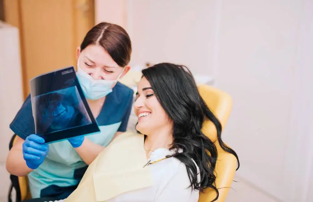 female-dentist-showing-teeth-x-ray-patient (1)